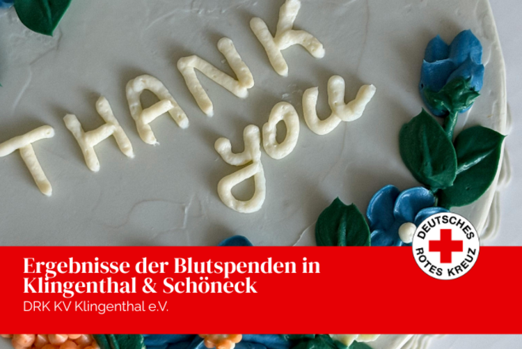 Eine Sahnetorte mit der Aufschrift Thank you in cremeweiß und als Deko blaue Marzipanblüten.